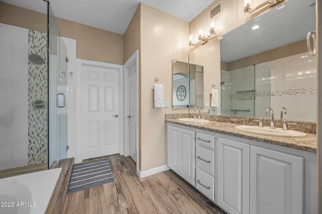 a spacious bathroom with a granite countertop sink a mirror and a shower
