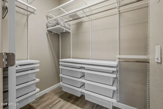 a view of walk in closet with empty racks