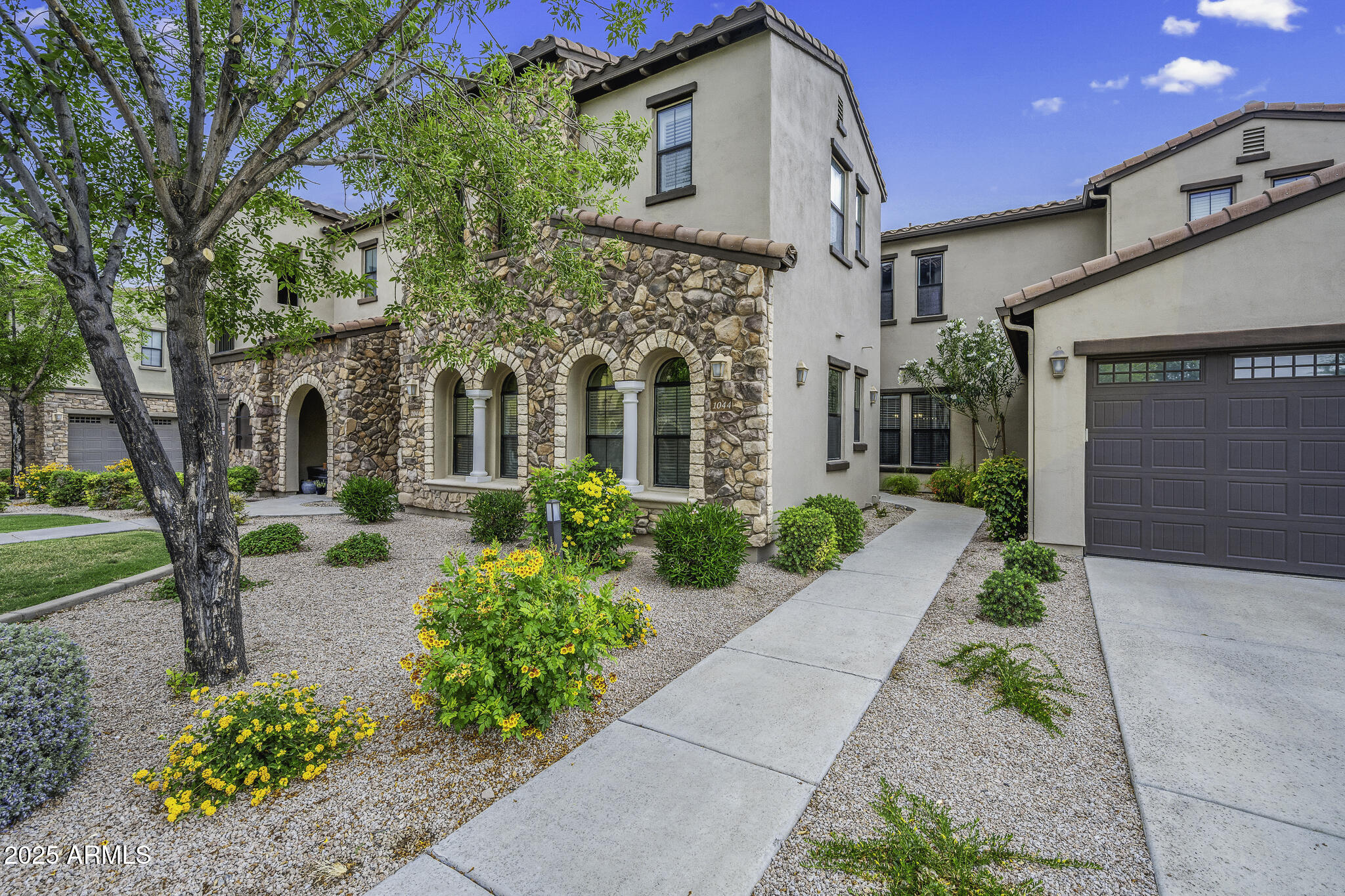 4777 South Fulton Ranch Boulevard, Unit 1044 Chandler, AZ 85248 - Photo 2 of 22 a front view of a house with garden