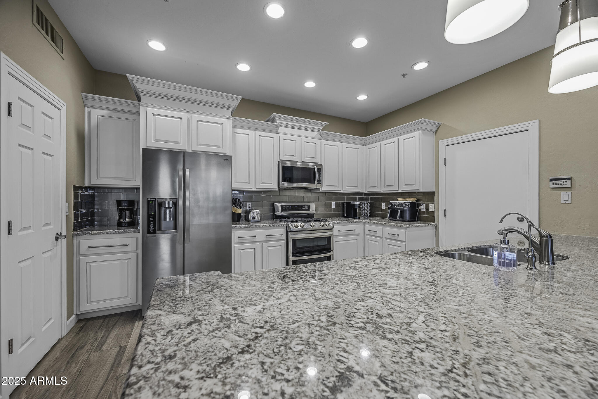 4777 South Fulton Ranch Boulevard, Unit 1044 Chandler, AZ 85248 - Photo 7 of 22 a kitchen with granite countertop a refrigerator and a stove top oven