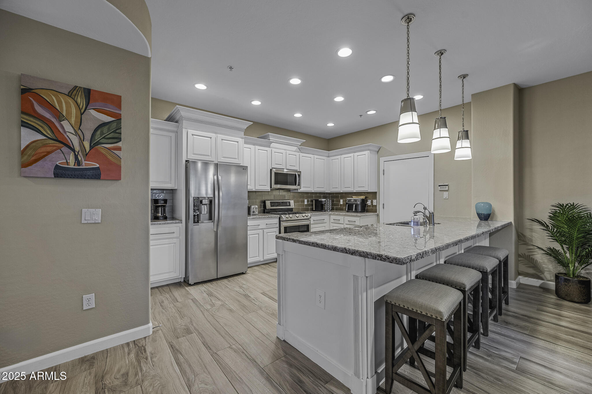 4777 South Fulton Ranch Boulevard, Unit 1044 Chandler, AZ 85248 - Photo 8 of 22 a kitchen with stainless steel appliances granite countertop a refrigerator a oven a sink a dining table and chairs with wooden floor