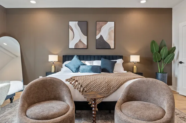 a bedroom with a bed and painting on the wall