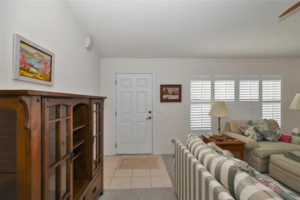 a living room with furniture two windows and a flat screen tv