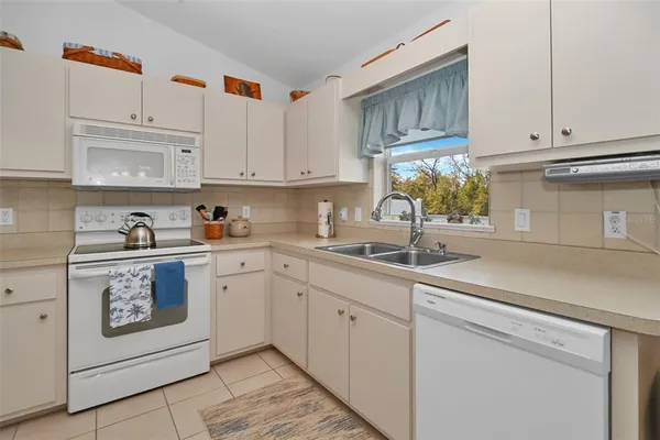 a kitchen with white cabinets and white appliances