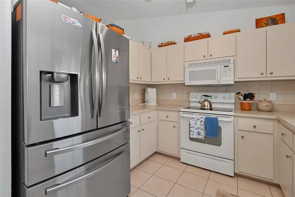 a kitchen with white cabinets and white appliances