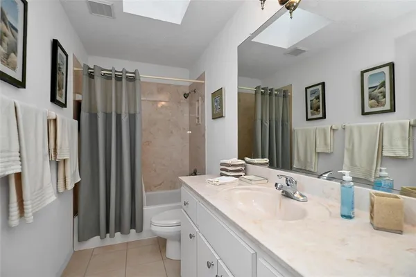 a bathroom with double vanity sink a toilet a mirror and shower