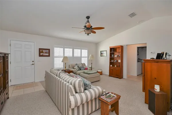 a living room with furniture a flat screen tv and a window