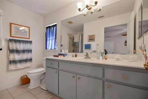 a bathroom with a double vanity sink mirror and toilet