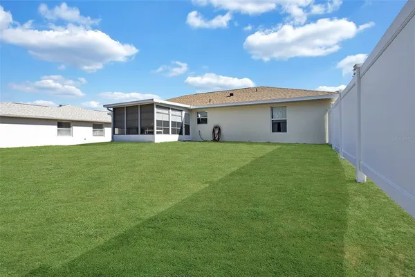 a view of a house with a big yard and potted plants