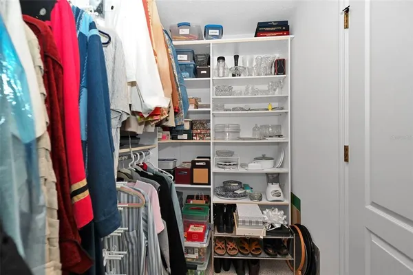 a view of walk in closet with clothes and shoes