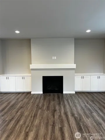 a view of empty room with wooden floor and fireplace