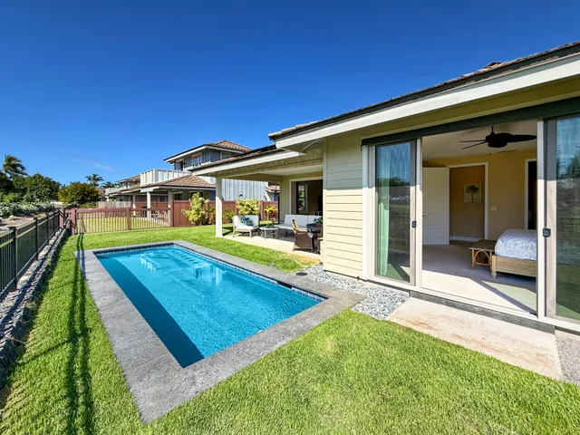a view of a house with pool and a yard
