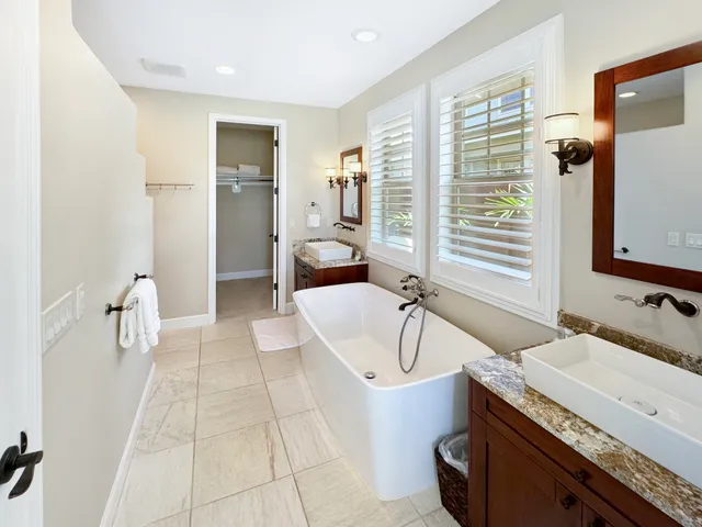 a spacious bathroom with a granite countertop tub sink a mirror and a shower