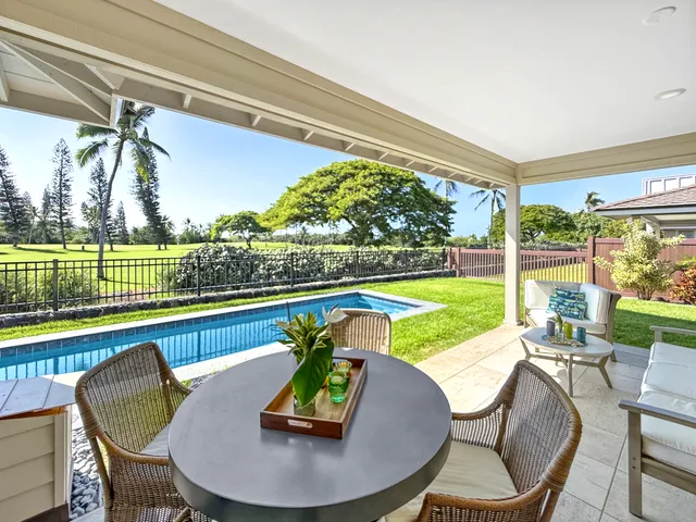 a view of a chairs and table in patio with a yard