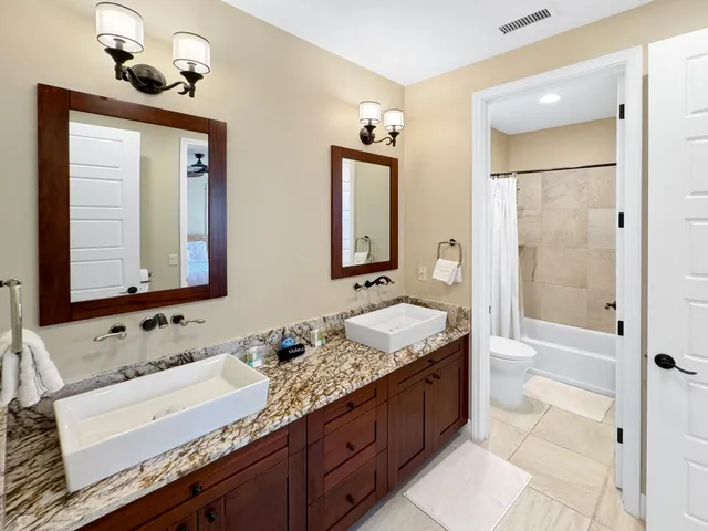 a bathroom with a granite countertop sink mirror and a bathtub