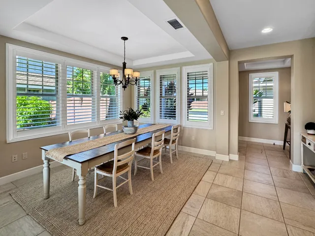 a dining room with furniture a chandelier and wooden floor