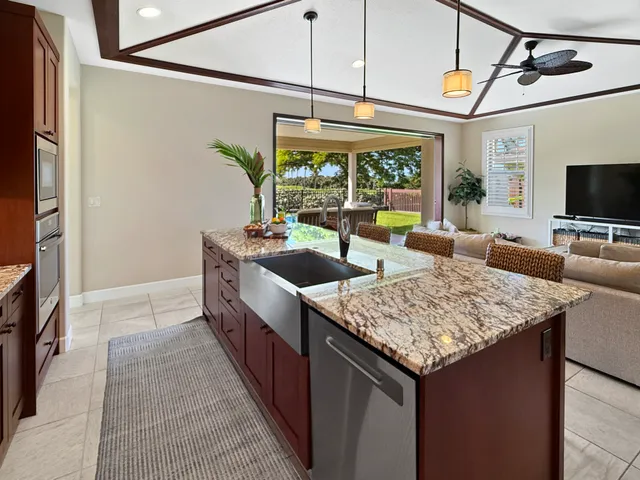 a kitchen with stainless steel appliances granite countertop a sink and a refrigerator