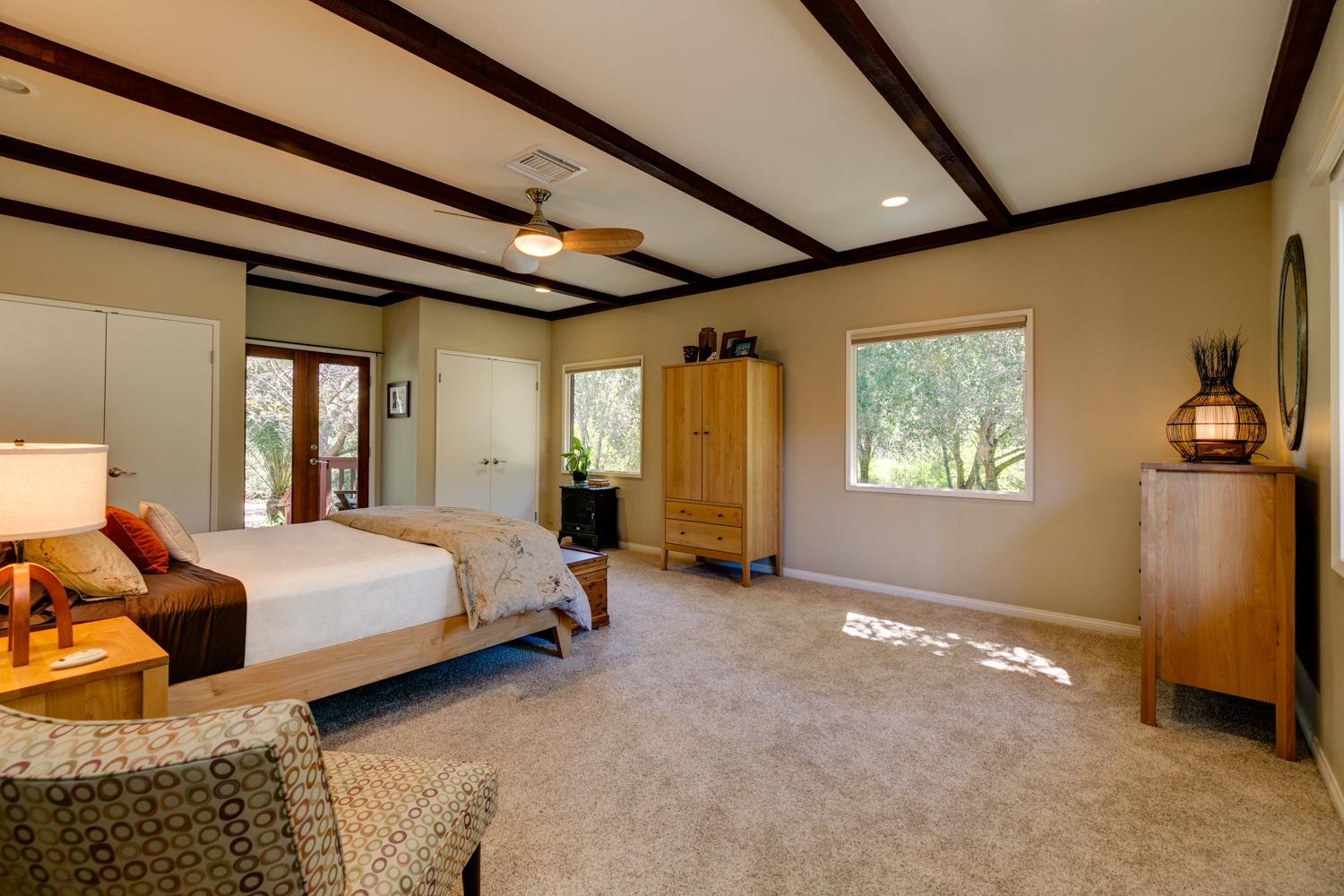 918 El Toro Road Ojai, CA 93023 - Photo 20 of 43 a spacious bedroom with a bed and a chandelier