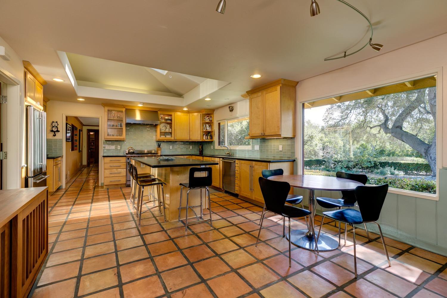 918 El Toro Road Ojai, CA 93023 - Photo 6 of 43 a open kitchen with stainless steel appliances kitchen island granite countertop a table chairs and a living room
