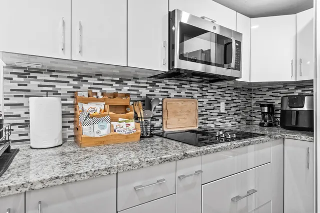 a kitchen with granite countertop stainless steel appliances a sink a stove and cabinets