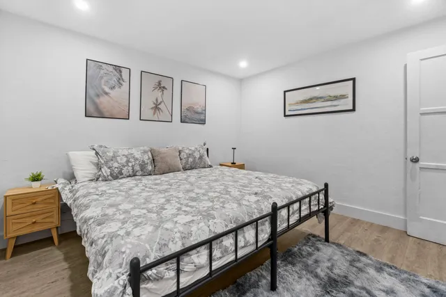 a bed room with a bed and painting on the wall