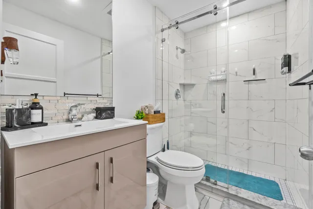 a bathroom with a sink a toilet and shower