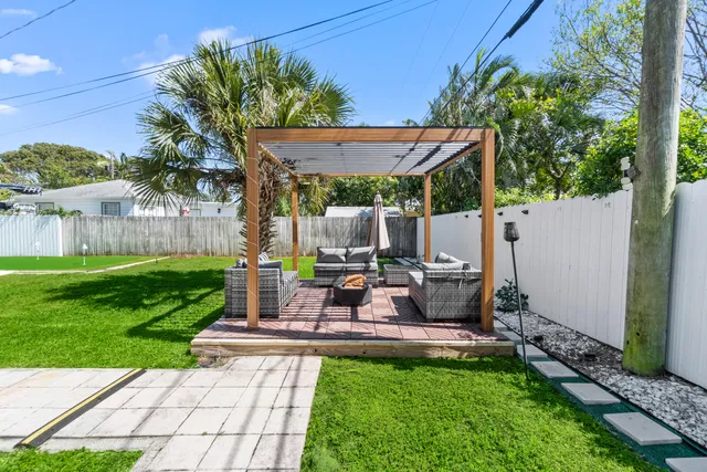 a view of a patio with table and chairs potted plants and a large tree