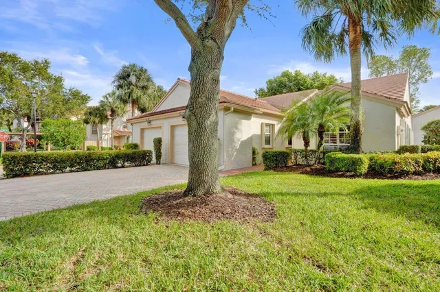 a kitchen with granite countertop a refrigerator sink and white cabinets