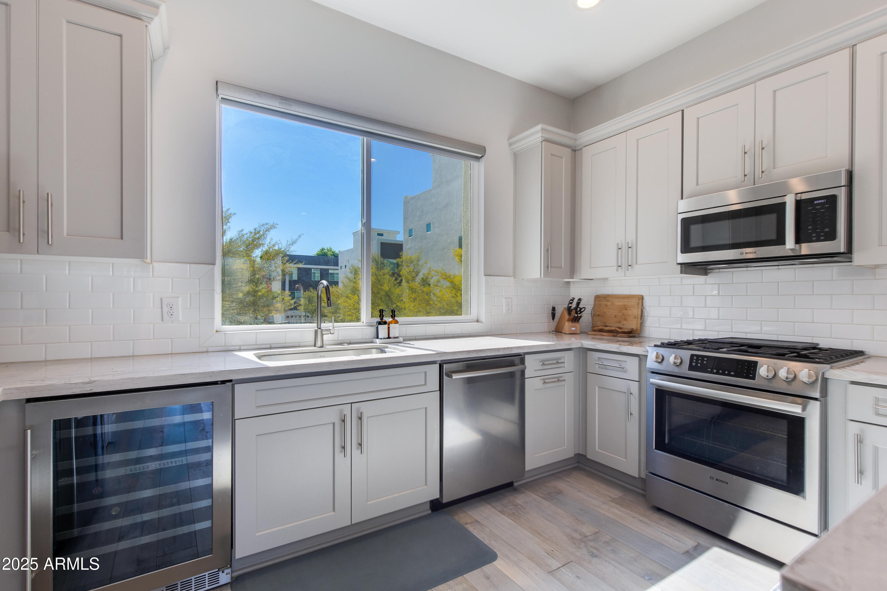 a kitchen with cabinets stainless steel appliances a sink and a window