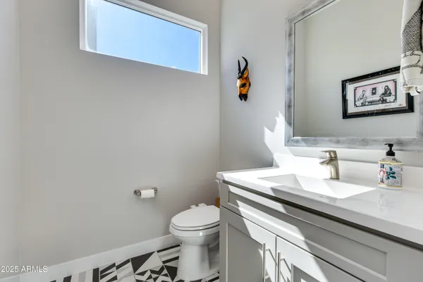a bathroom with a sink mirror vanity and toilet