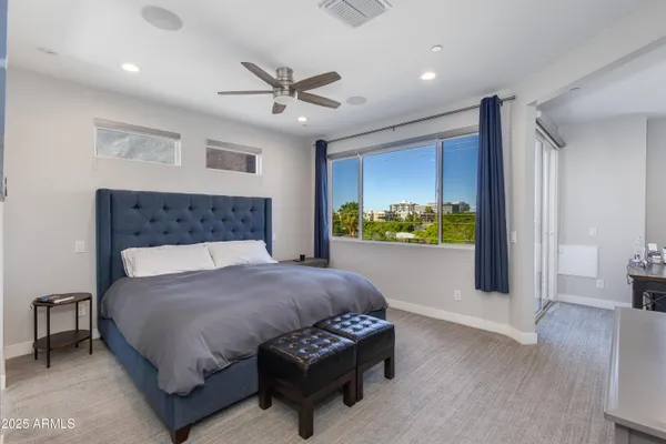 a bedroom with a bed mirror and window