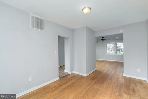 a view of an empty room with window and wooden floor