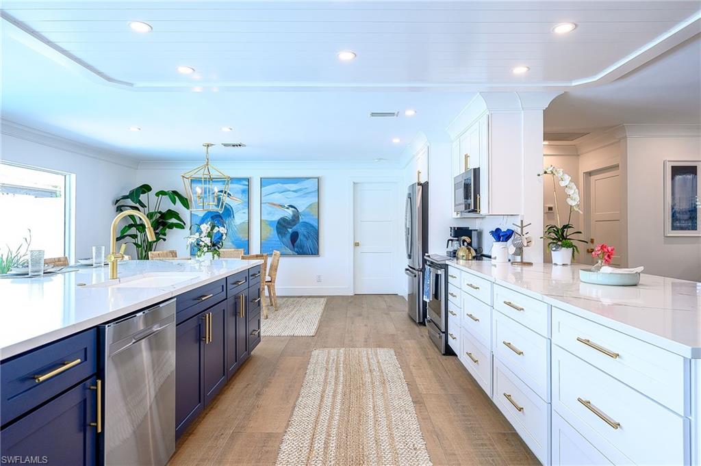 343 Conners Avenue Naples, FL 34108 - Photo 13 of 34 a large kitchen with stainless steel appliances kitchen island granite countertop a large counter top and sink