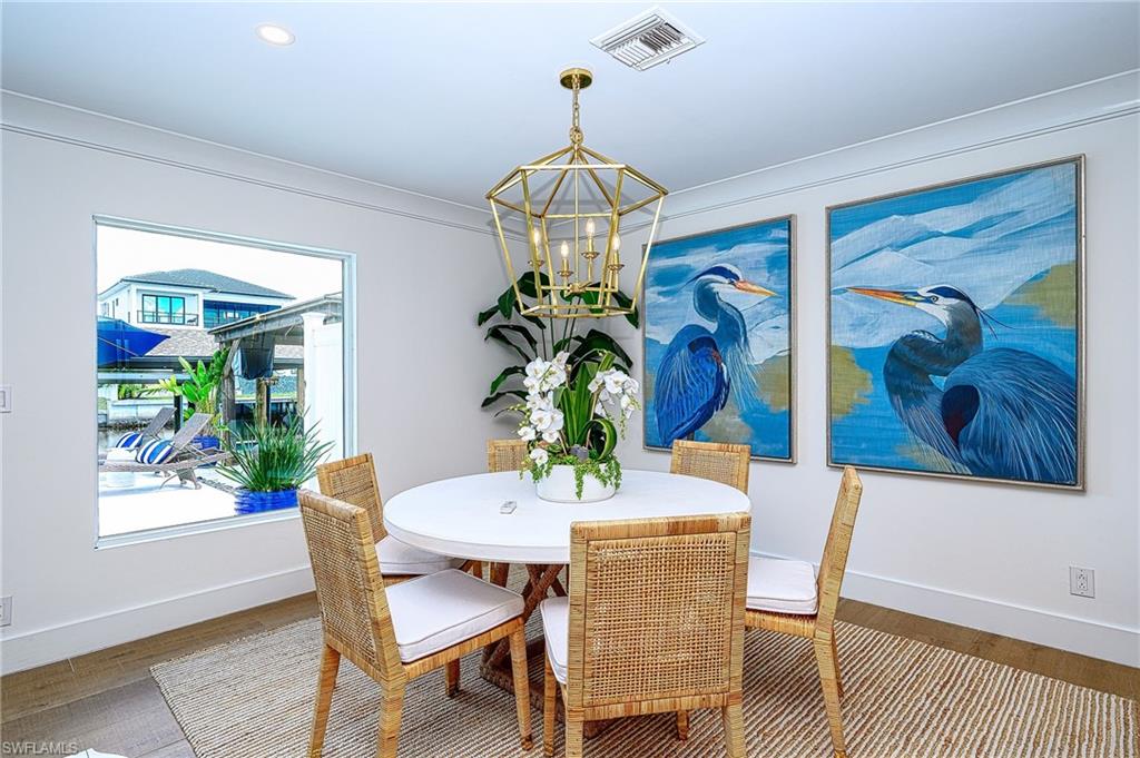 343 Conners Avenue Naples, FL 34108 - Photo 15 of 34 a dining room with furniture potted plants and wooden floor