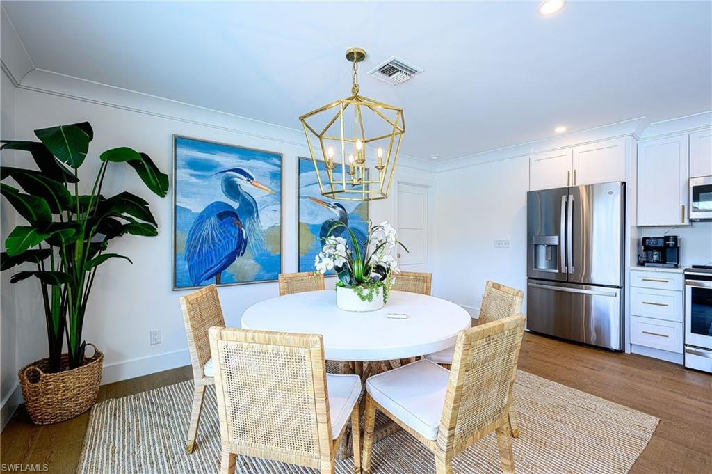 343 Conners Avenue Naples, FL 34108 - Photo 16 of 34 a view of a dining room with furniture wooden floor and a chandelier