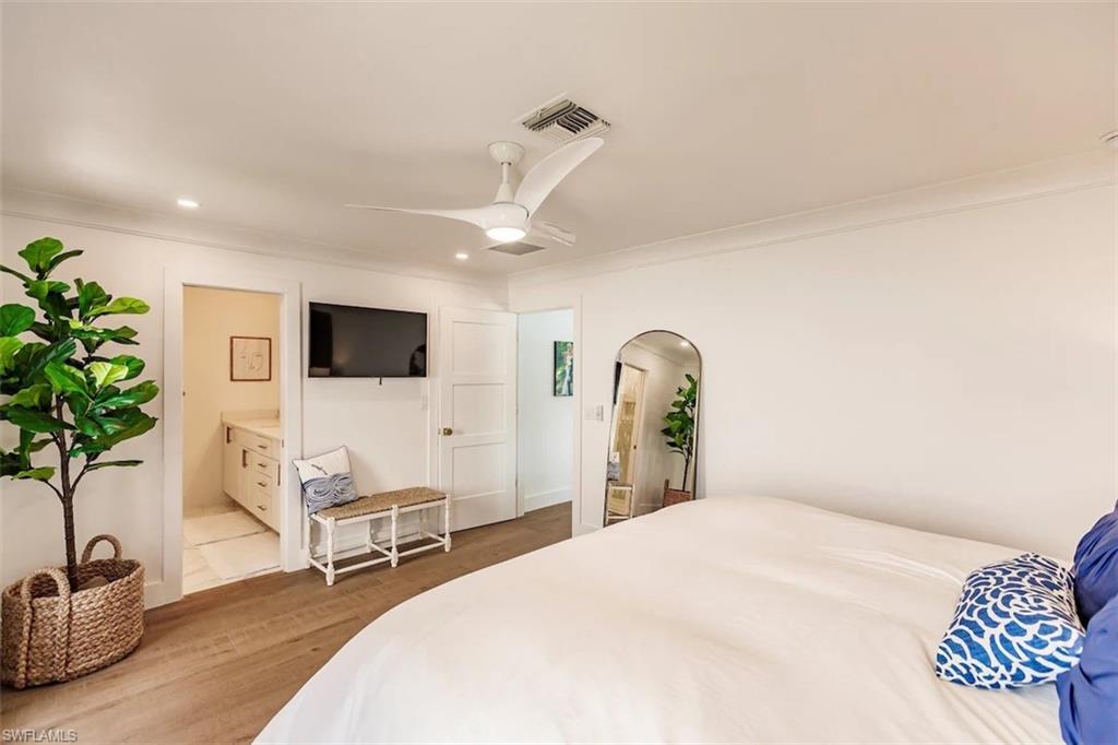 343 Conners Avenue Naples, FL 34108 - Photo 19 of 34 a bedroom with a bed and a flat screen tv