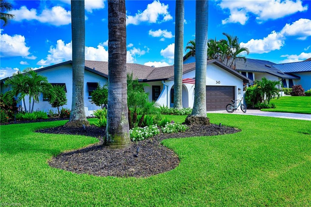 343 Conners Avenue Naples, FL 34108 - Photo 2 of 34 a front view of a residential houses with yard and green space