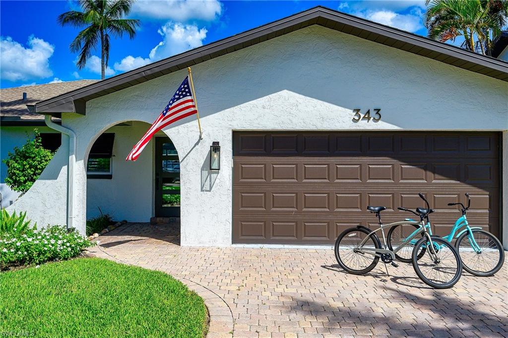 343 Conners Avenue Naples, FL 34108 - Photo 32 of 34 a front view of a house with garden