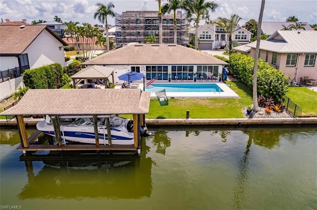 343 Conners Avenue Naples, FL 34108 - Photo 33 of 34 an aerial view of a swimming pool with outdoor seating and lake view