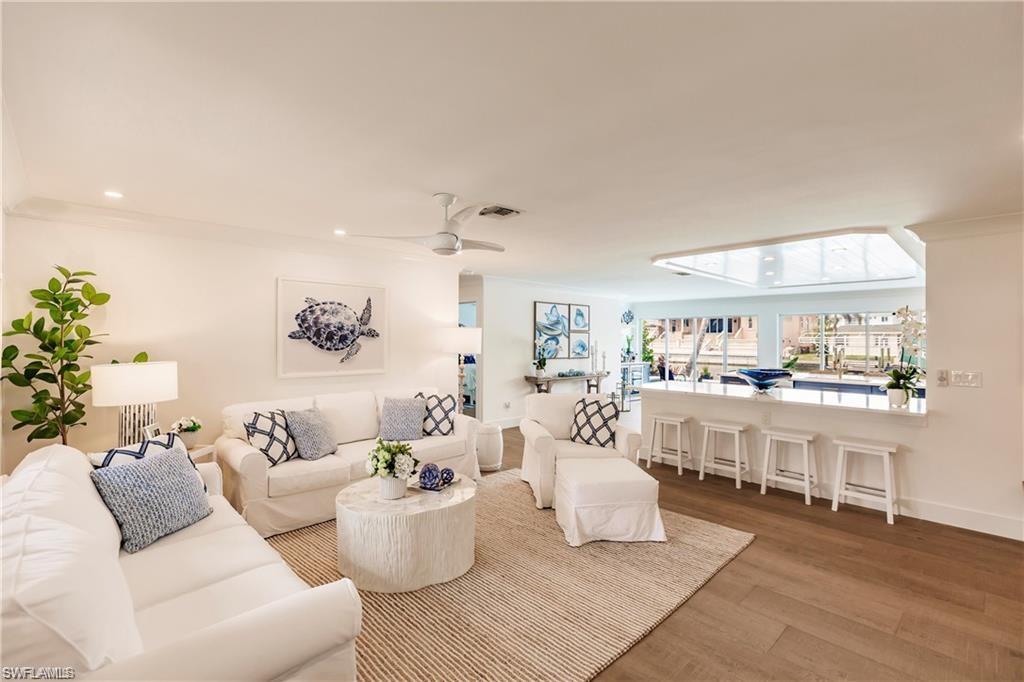 343 Conners Avenue Naples, FL 34108 - Photo 7 of 34 a living room with furniture and a wooden floor
