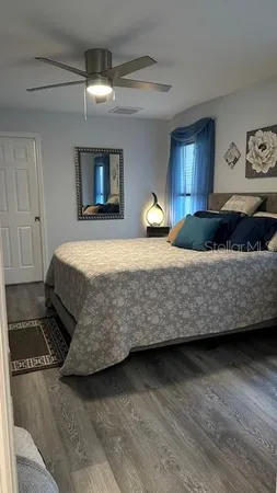 a bedroom with a bed and wooden floor
