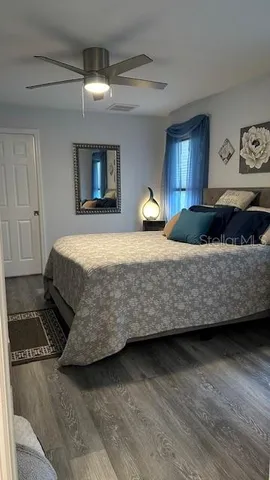 a bedroom with a bed and wooden floor