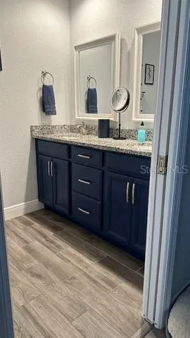 a bathroom with a granite countertop sink and a mirror