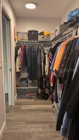 a view of walk in closet with clothes and shoes