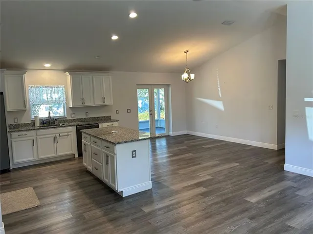 a kitchen with granite countertop a stove top oven and cabinets
