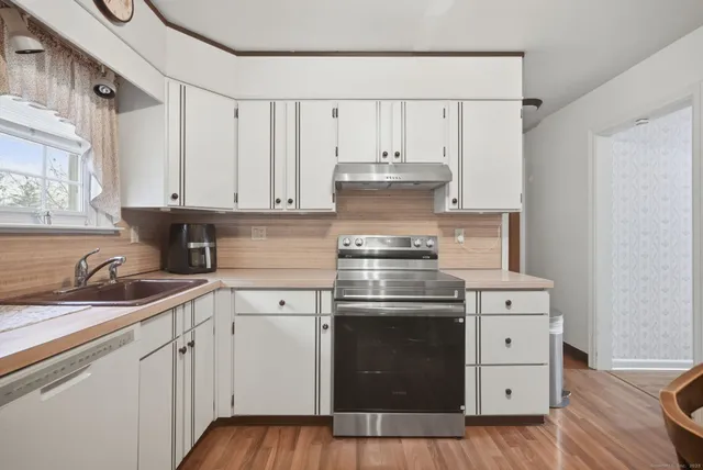 a kitchen with cabinets appliances a sink and a counter top space