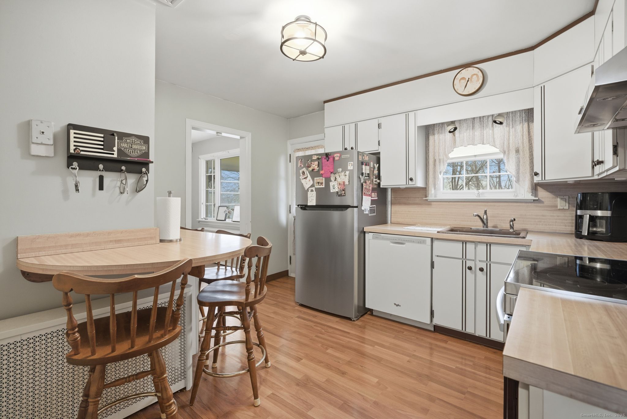 23 Baldwin Street Meriden, CT 06451 - Photo 15 of 40 a kitchen with stainless steel appliances granite countertop a stove a refrigerator a microwave a dining table and chairs with wooden floor