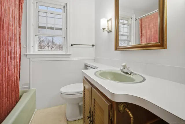 a bathroom with a sink a toilet and a mirror