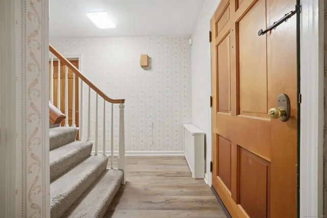a view of a hallway with wooden floor and staircase