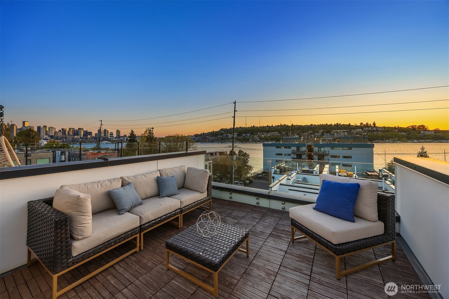 a roof deck with couches and potted plants